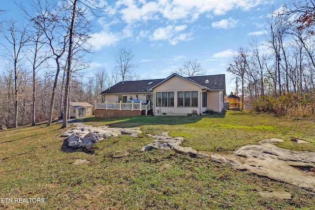 rear view of property featuring a yard and a shed