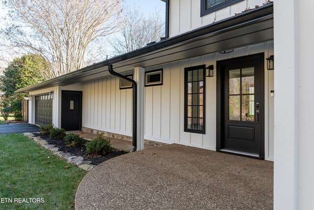12000 S Fox Den Dr, Knoxville, TN 37934 - view of exterior entry with board and batten siding, asphalt driveway, and a garage