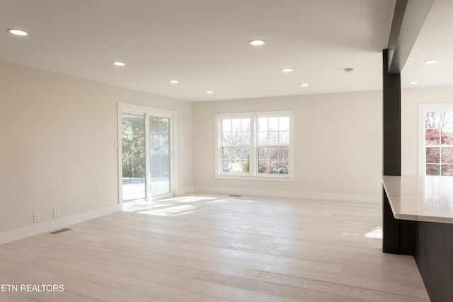 unfurnished living room featuring light wood-type flooring and a healthy amount of sunlight