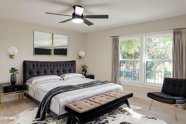 bedroom featuring ceiling fan, light hardwood / wood-style flooring, and multiple windows