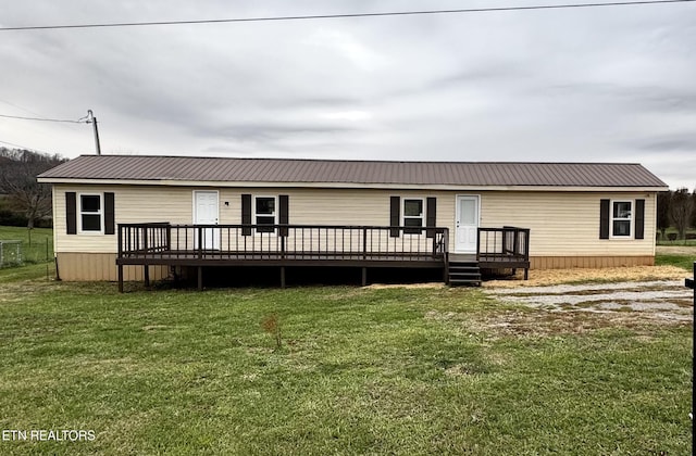 back of property featuring a yard and a wooden deck