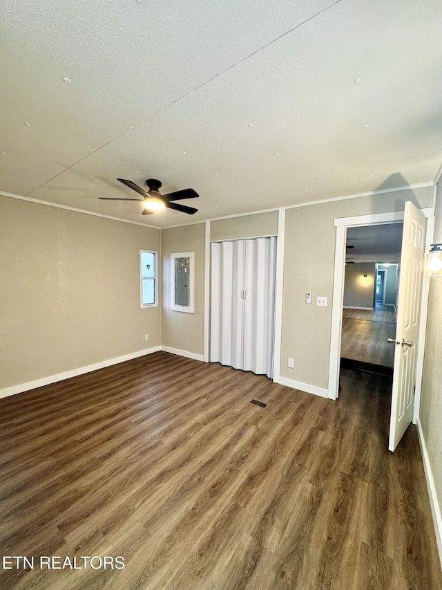 unfurnished bedroom with a textured ceiling, crown molding, ceiling fan, and dark wood-type flooring