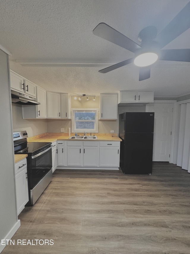 kitchen featuring black refrigerator, white cabinets, stainless steel range with electric cooktop, and sink