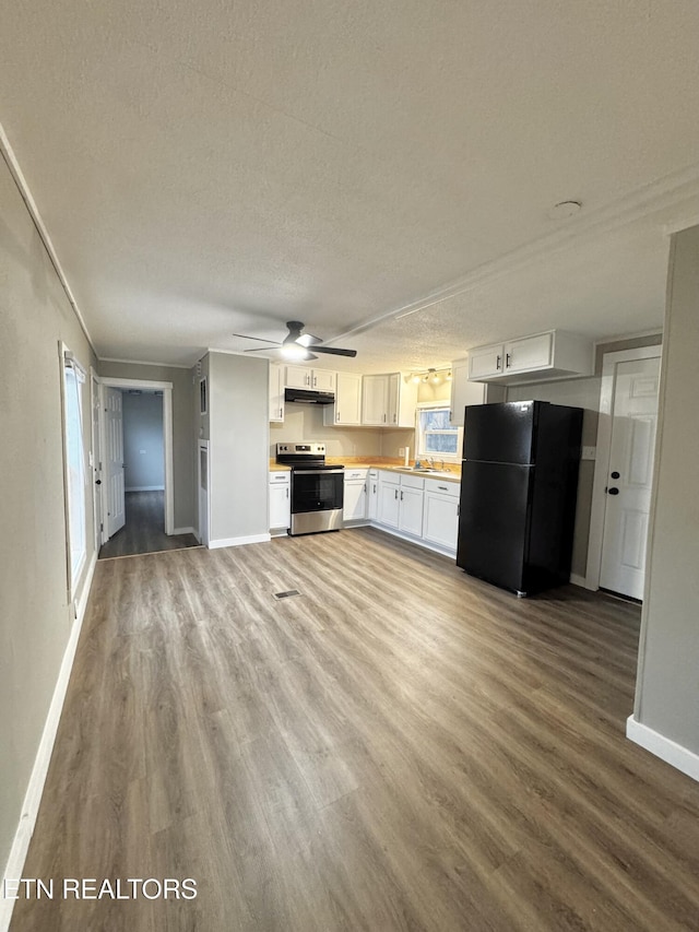 kitchen featuring black refrigerator, a textured ceiling, electric range, hardwood / wood-style flooring, and white cabinetry