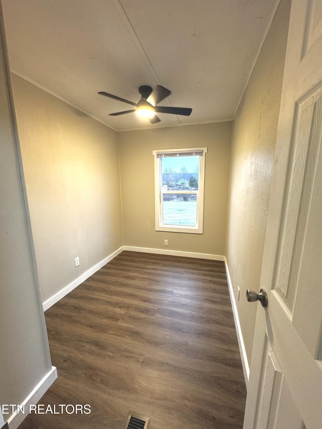 empty room featuring dark hardwood / wood-style floors, ceiling fan, and crown molding