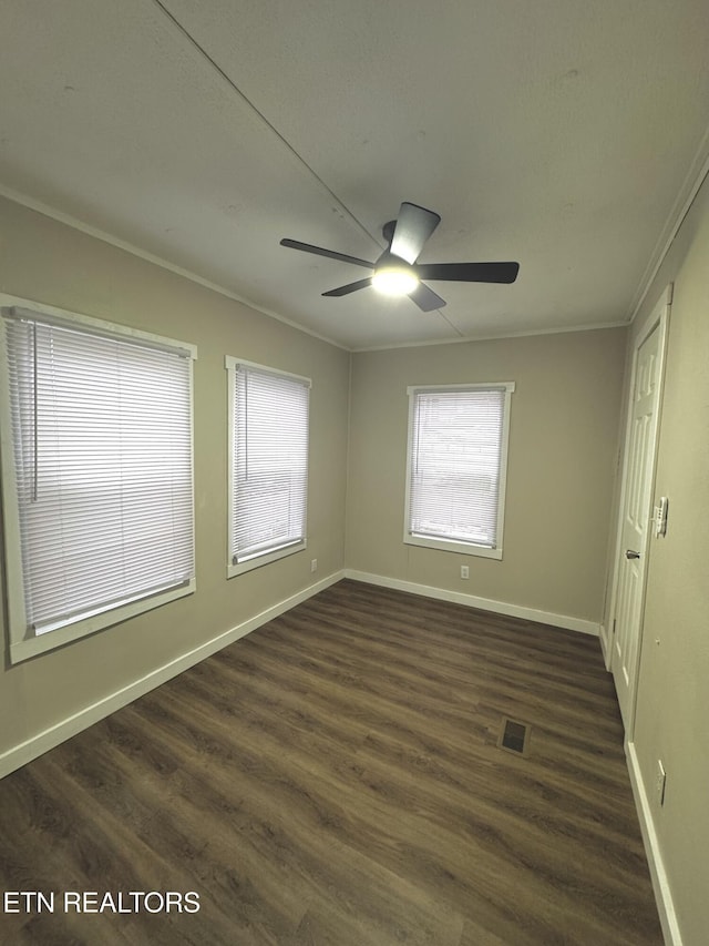 empty room featuring ceiling fan, dark hardwood / wood-style floors, and ornamental molding