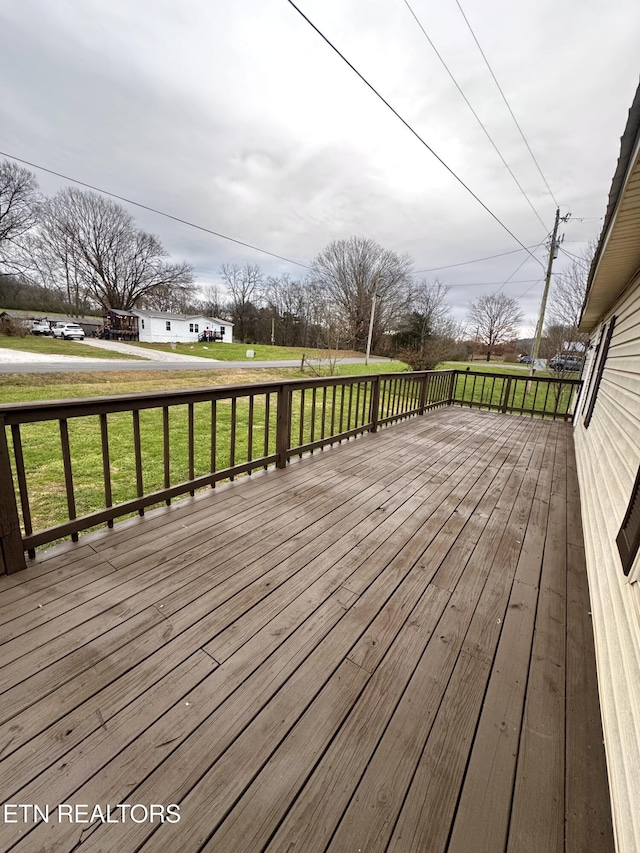 wooden terrace featuring a lawn