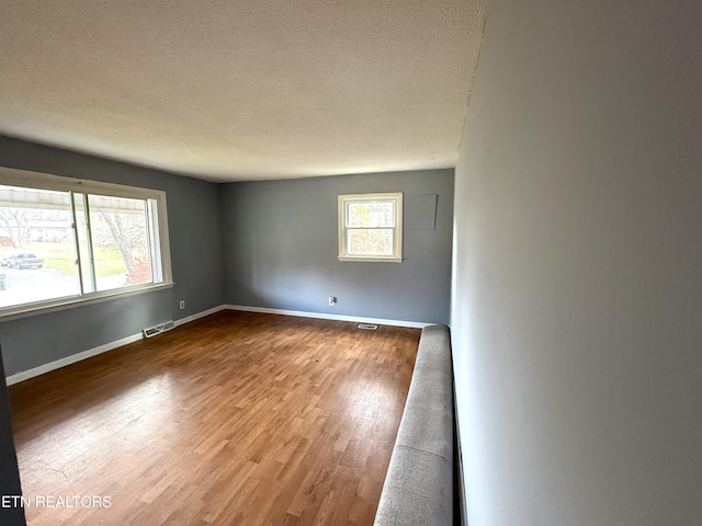 empty room featuring a textured ceiling and hardwood / wood-style flooring