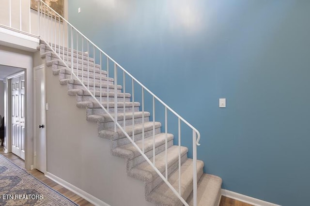 staircase with hardwood / wood-style floors