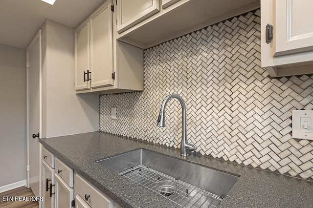 kitchen featuring tasteful backsplash, white cabinetry, dark hardwood / wood-style floors, and sink