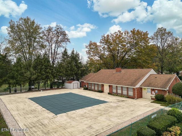 view of swimming pool with a patio and a shed