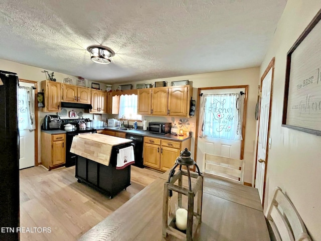 kitchen featuring sink, a textured ceiling, light wood-type flooring, and black appliances