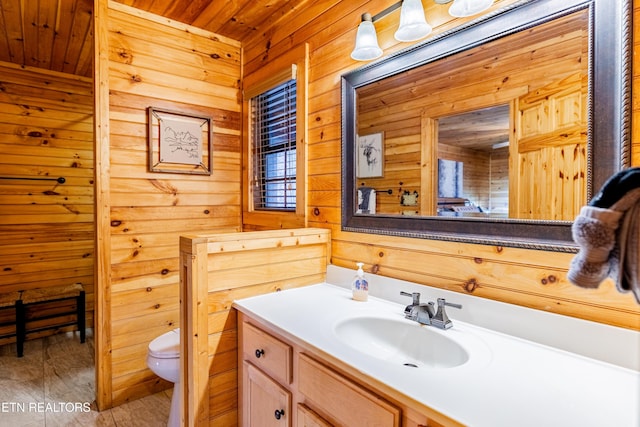 bathroom featuring vanity, toilet, wooden ceiling, and wood walls