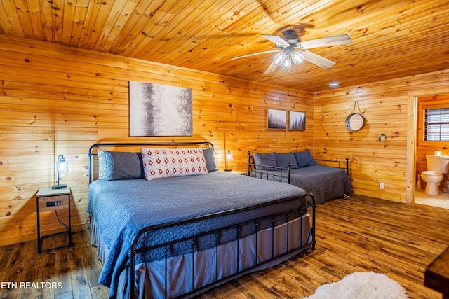 bedroom featuring wood walls, wood-type flooring, ceiling fan, connected bathroom, and wood ceiling