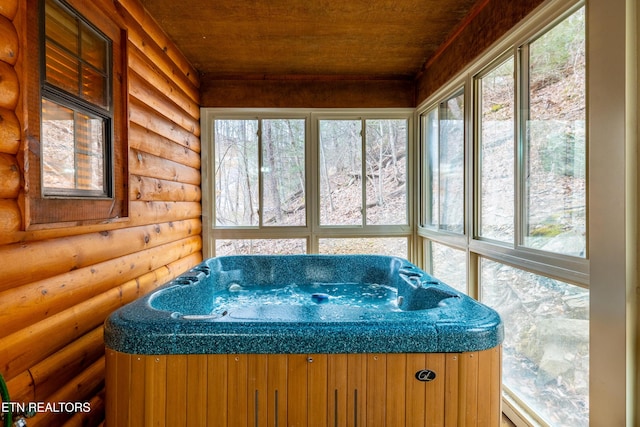 sunroom with plenty of natural light, wooden ceiling, and a hot tub