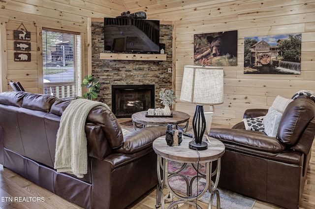 living room with light wood-type flooring, a fireplace, and wooden walls