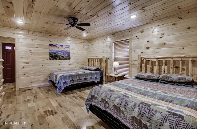 bedroom with wood walls, ceiling fan, wood ceiling, and light hardwood / wood-style flooring