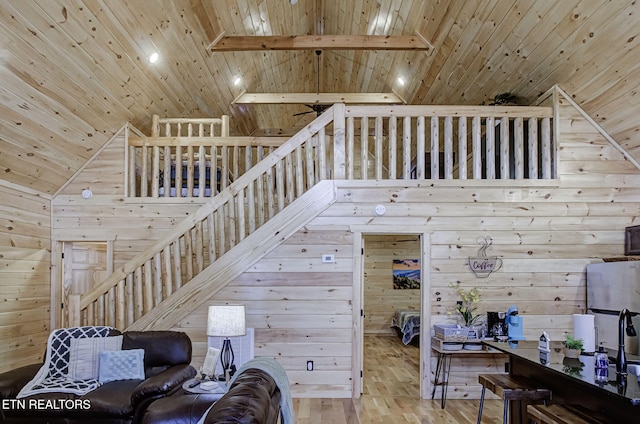 living room featuring wood ceiling, beam ceiling, wood walls, and light hardwood / wood-style floors