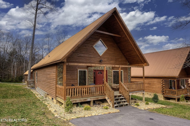 cabin featuring a front lawn and covered porch