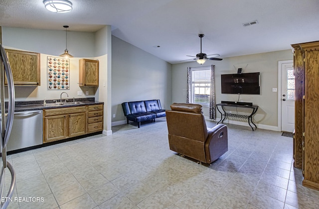 living room featuring ceiling fan, a healthy amount of sunlight, lofted ceiling, and sink