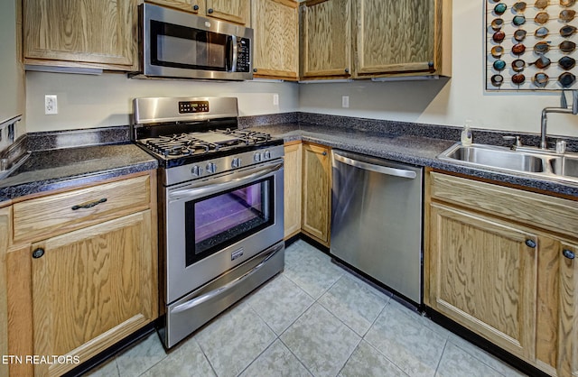 kitchen featuring light tile patterned flooring, sink, and stainless steel appliances