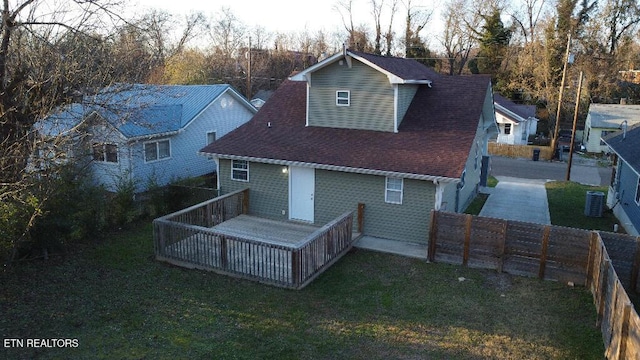 rear view of property featuring central AC unit and a yard