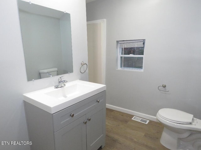 bathroom featuring hardwood / wood-style floors, vanity, and toilet