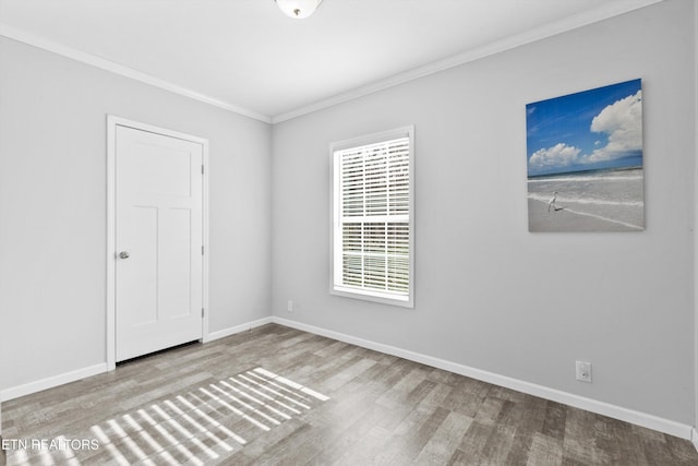 empty room with light hardwood / wood-style floors and ornamental molding