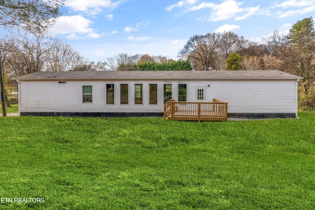 back of house featuring a lawn and a wooden deck