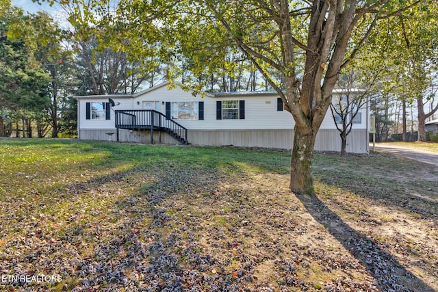 view of front facade with a wooden deck and a front lawn