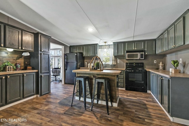 kitchen with a breakfast bar, vaulted ceiling, dark wood-type flooring, sink, and black appliances