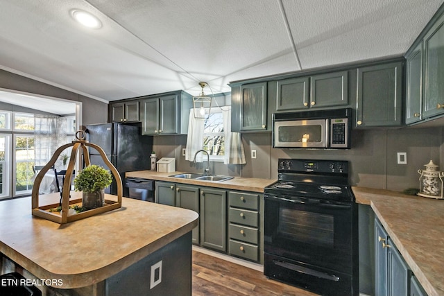 kitchen with dark wood-type flooring, sink, black appliances, and vaulted ceiling