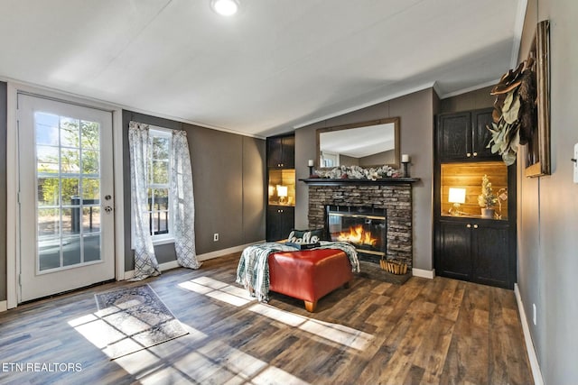 living room featuring a fireplace, hardwood / wood-style floors, vaulted ceiling, and ornamental molding