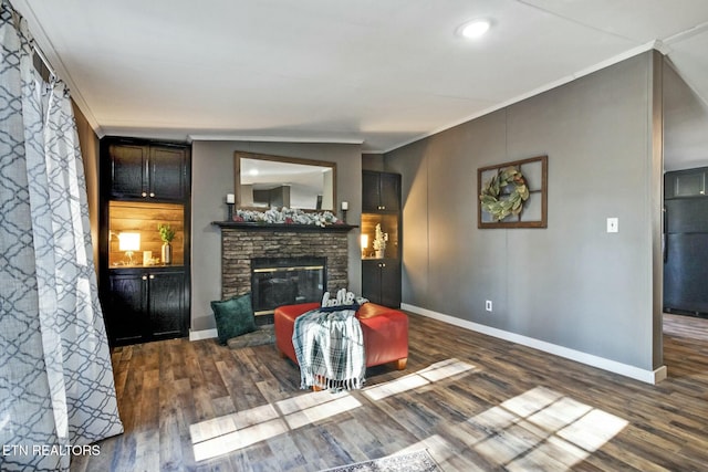 living room featuring a stone fireplace, crown molding, and dark hardwood / wood-style floors