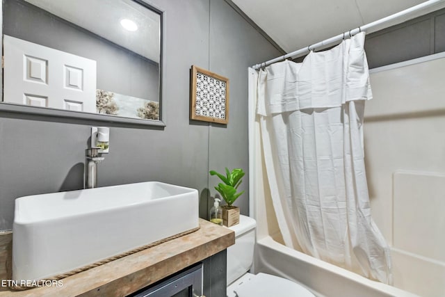 full bathroom featuring toilet, shower / tub combo with curtain, and sink