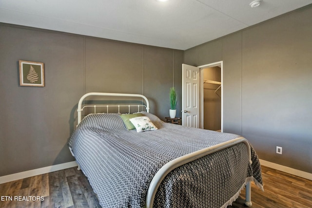 bedroom featuring a closet, a spacious closet, and dark hardwood / wood-style flooring