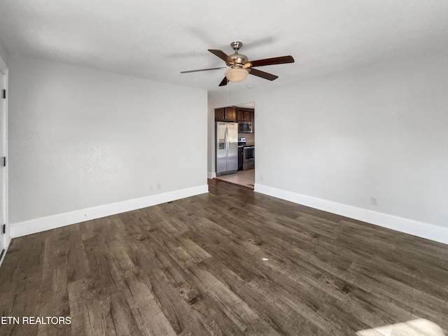 spare room featuring ceiling fan and dark wood-type flooring