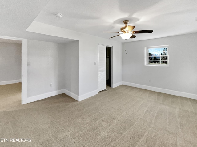 unfurnished room featuring a textured ceiling, light colored carpet, and ceiling fan