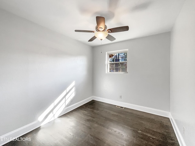 empty room with dark hardwood / wood-style floors and ceiling fan