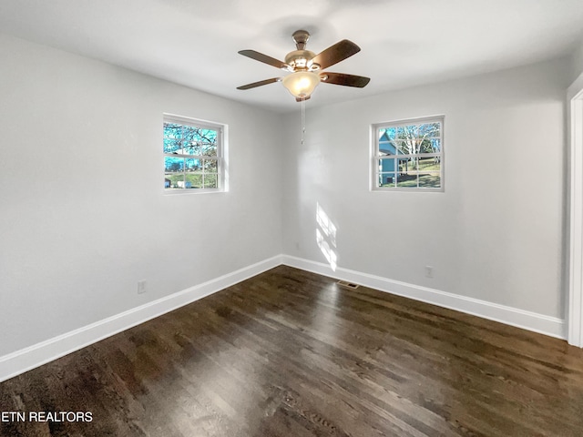 empty room with a wealth of natural light, ceiling fan, and dark hardwood / wood-style floors