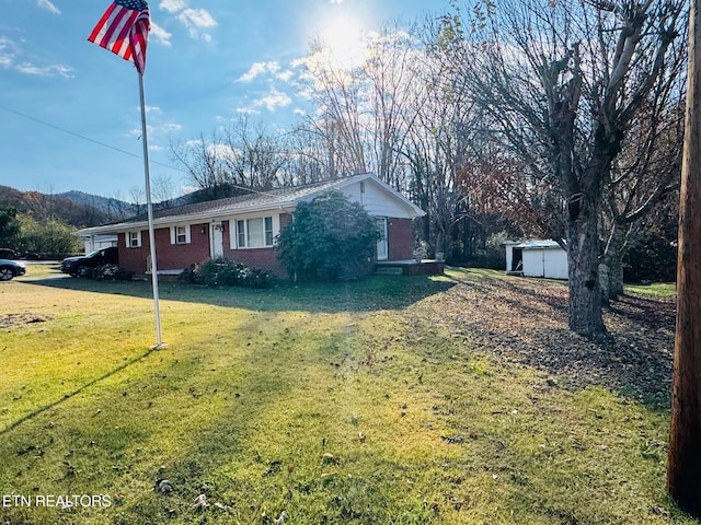 115 Greasy Cove Rd, Cosby, TN 37722 - view of front of home with brick siding, a shed, and a front lawn