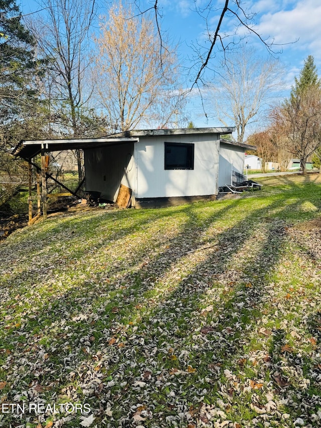 view of side of property with a lawn and a carport