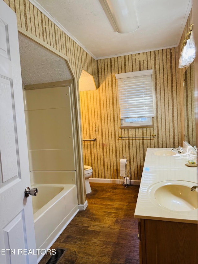 bathroom with hardwood / wood-style flooring, vanity, toilet, and crown molding