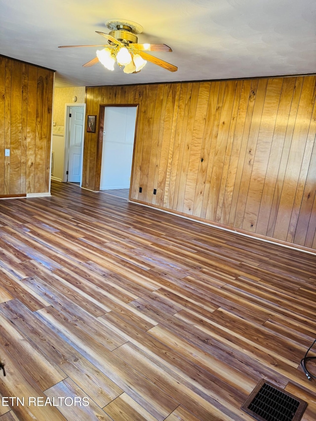 spare room featuring hardwood / wood-style floors and wood walls