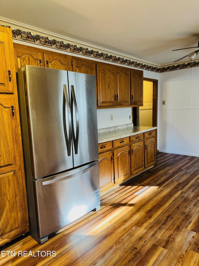 kitchen with dark hardwood / wood-style floors, stainless steel fridge, ornamental molding, and ceiling fan