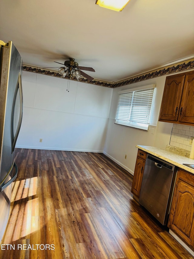 kitchen featuring tasteful backsplash, ceiling fan, stainless steel appliances, and dark hardwood / wood-style floors