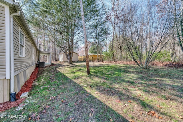 view of yard with central AC unit and a shed