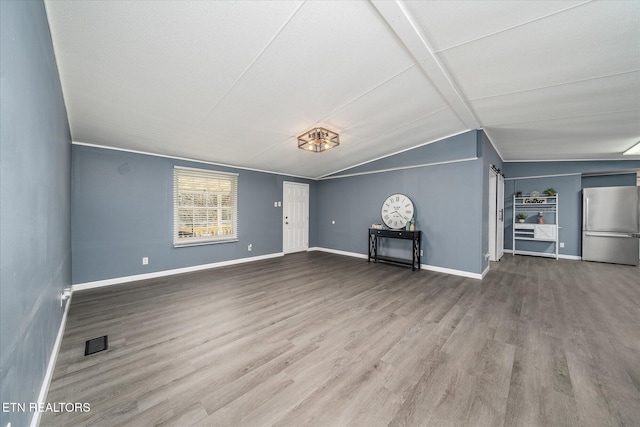 unfurnished living room with hardwood / wood-style flooring and lofted ceiling