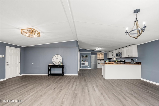 kitchen featuring wooden counters, stainless steel appliances, pendant lighting, white cabinets, and hardwood / wood-style floors