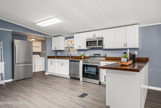 kitchen with washing machine and clothes dryer, white cabinets, stainless steel appliances, and light hardwood / wood-style floors